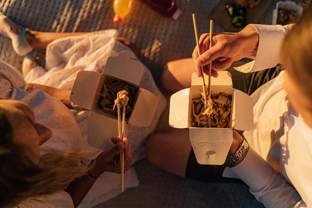 People eating takeaway food from packaging boxes