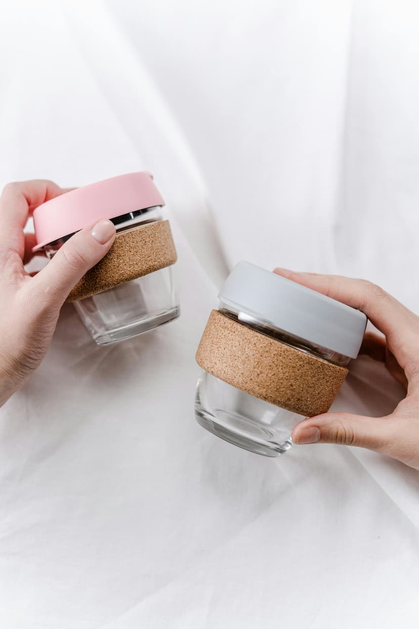 Glass cups with cork bands being held